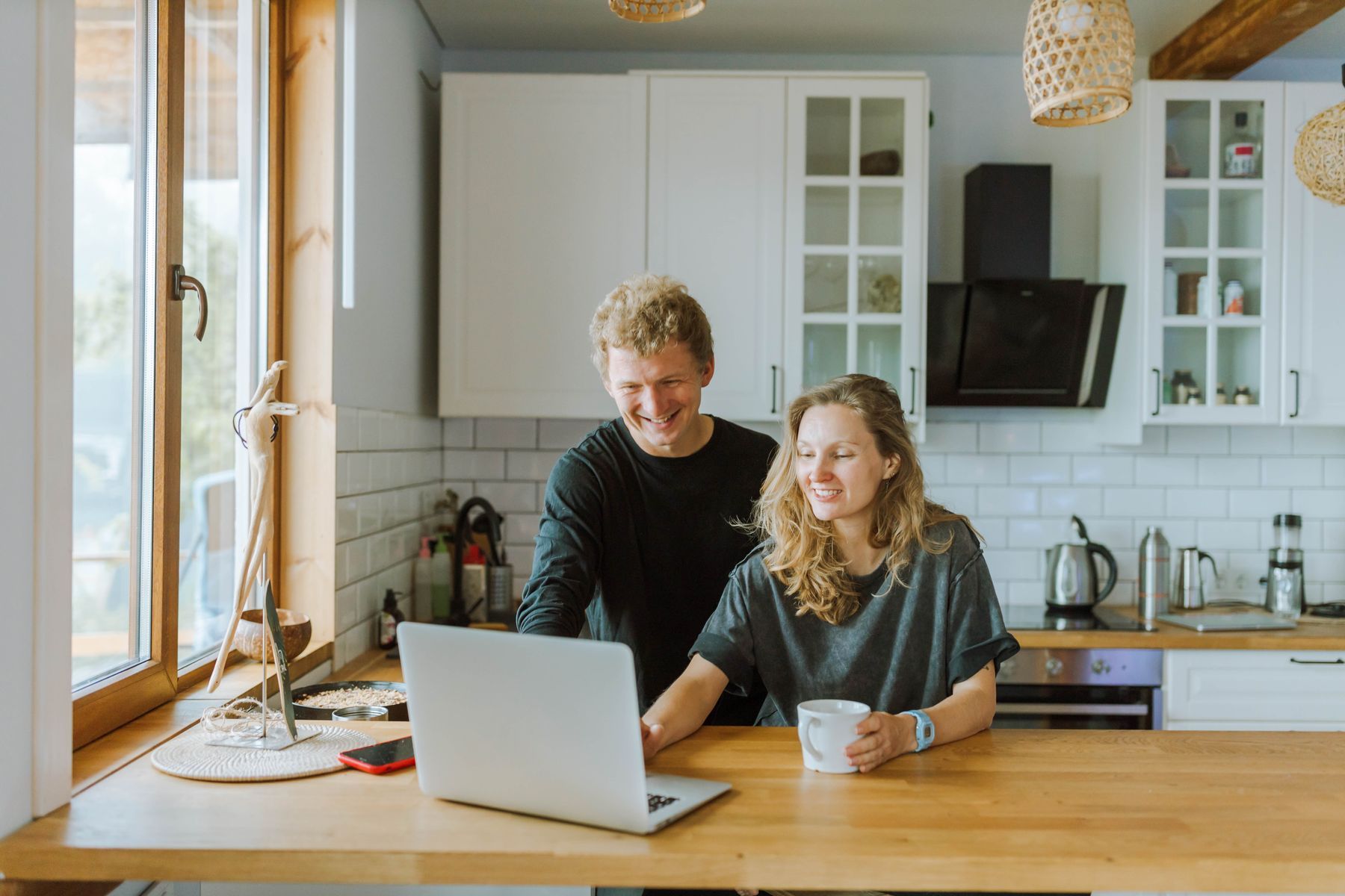A couple at their kitchen table checking an already lodged tax return on a laptop